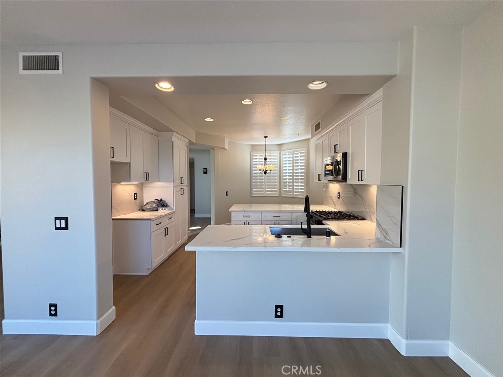 15252 Riviera Lane La Mirada, CA 90638 - Photo 4 of 18 a view of a kitchen with kitchen island a sink stainless steel appliances and cabinets