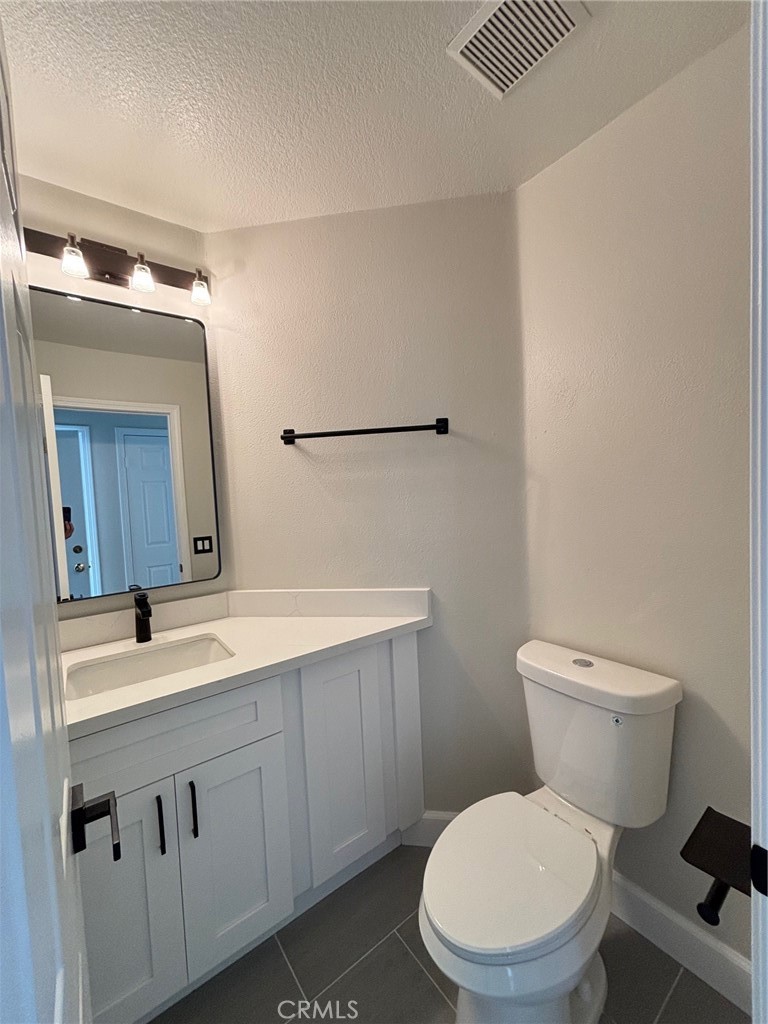 15252 Riviera Lane La Mirada, CA 90638 - Photo 7 of 18 a bathroom with a toilet a sink a mirror and vanity