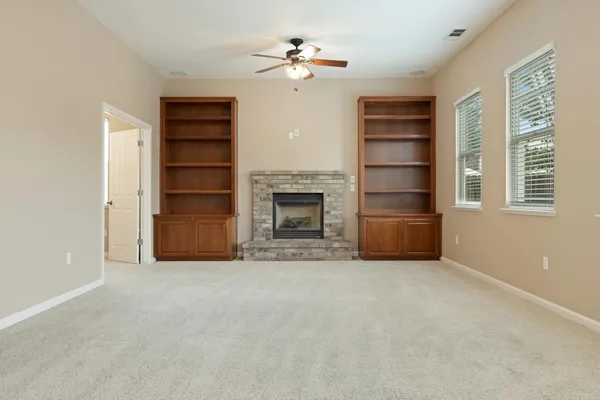 a view of an empty room with a fireplace and a window
