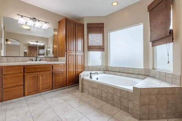 a spacious bathroom with a tub sink and mirror