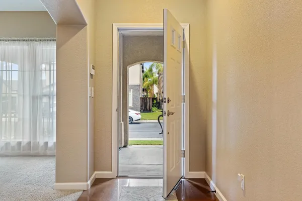 a view of a hallway with wooden floor and a living room