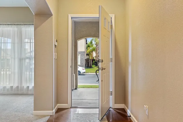 a view of a hallway with wooden floor and a living room