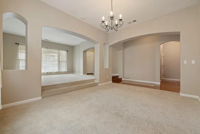 a view of an empty room with a chandelier