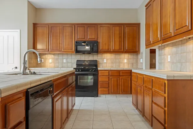 a kitchen with stainless steel appliances granite countertop a stove sink and cabinets