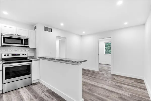 a kitchen with stainless steel appliances a stove microwave and a refrigerator