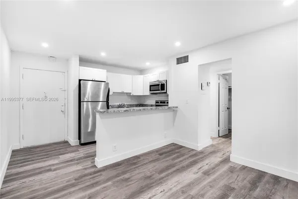 a kitchen with stainless steel appliances a refrigerator and a stove top oven