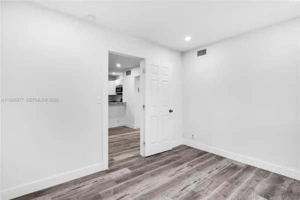a view of empty room with wooden floor