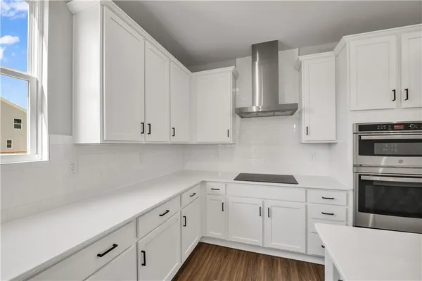 a kitchen with white cabinets and white appliances