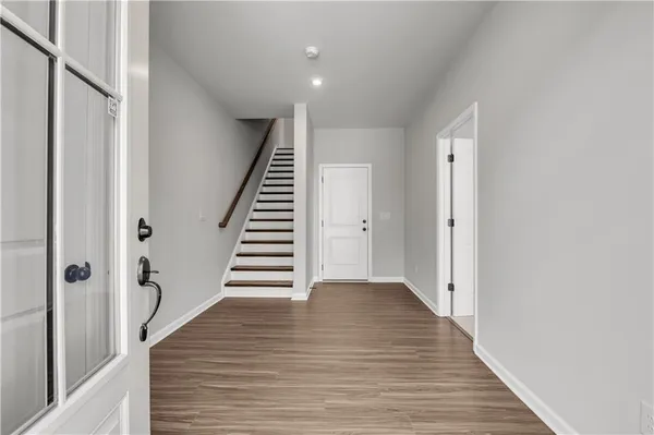 a view of a hallway with wooden floor and staircase