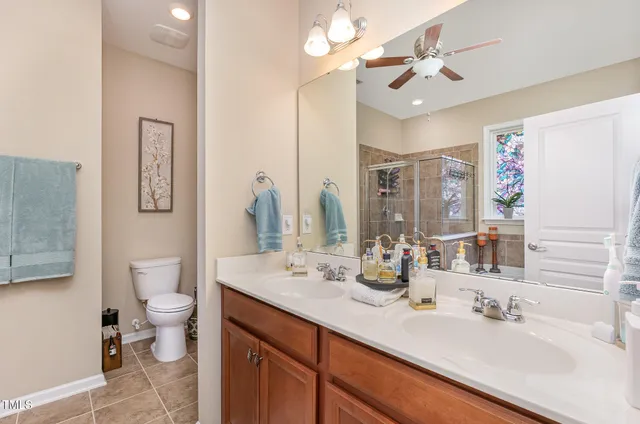 a bathroom with a double vanity sink mirror and toilet