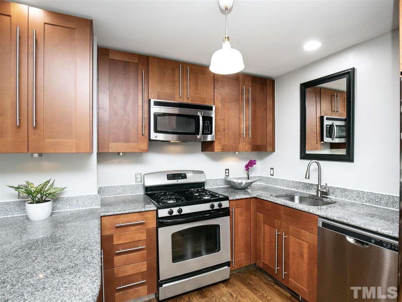 2542 Noble Road Raleigh, NC 27608 - Photo 11 of 27 a kitchen with stainless steel appliances granite countertop a sink a stove and a microwave