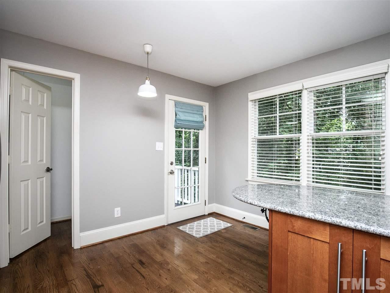 2542 Noble Road Raleigh, NC 27608 - Photo 12 of 27 a view of an empty room with wooden floor and a window