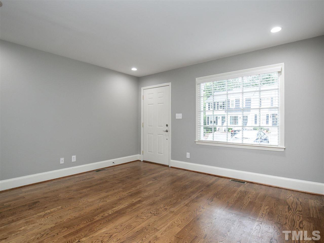 2542 Noble Road Raleigh, NC 27608 - Photo 6 of 27 an empty room with wooden floor and windows
