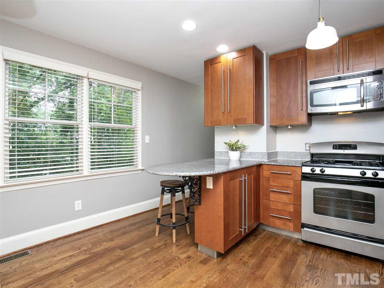 2542 Noble Road Raleigh, NC 27608 - Photo 10 of 27 a kitchen with stainless steel appliances granite countertop a stove a sink and a microwave