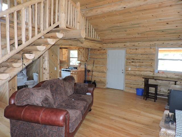 6548 Giesse Road San Luis, CO 81152 - Photo 15 of 45 a living room with furniture a fireplace and a dining table with wooden floor