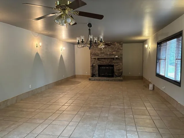 a view of empty room with a fireplace and chandelier