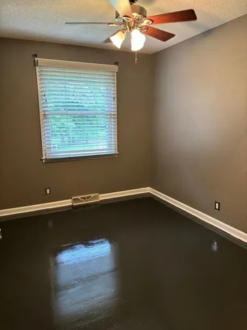 a room with a window and ceiling fan
