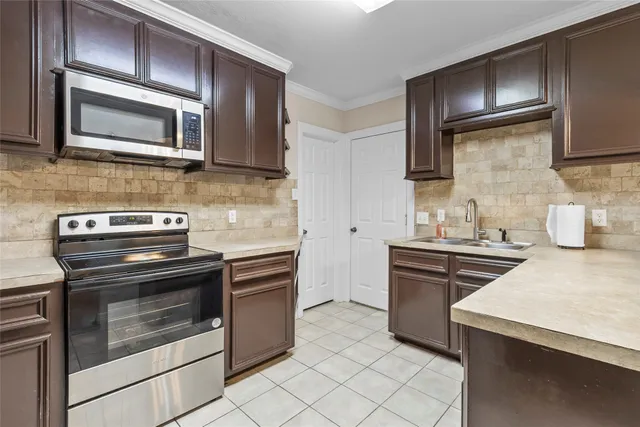 a kitchen with stainless steel appliances a stove microwave and sink