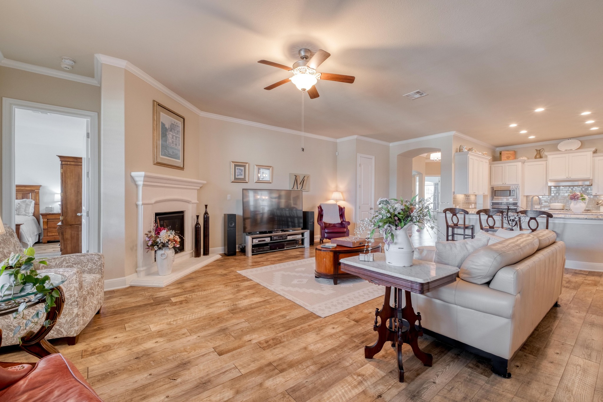 3204 Venezia View Leander, TX 78641 - Photo 5 of 28 Living area with wide-angle view featuring a fireplace with raised hearth, ceiling fan, arched walkways, and decorative
molding