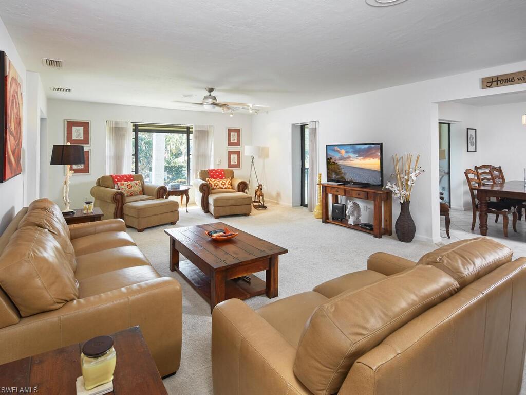 415 10th Avenue South, Unit 7 Naples, FL 34102 - Photo 4 of 15 a living room with furniture and a flat screen tv