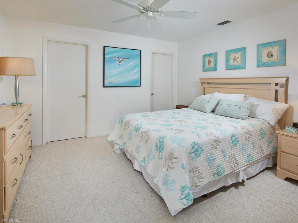 415 10th Avenue South, Unit 7 Naples, FL 34102 - Photo 10 of 15 a bedroom with a bed and a chandelier