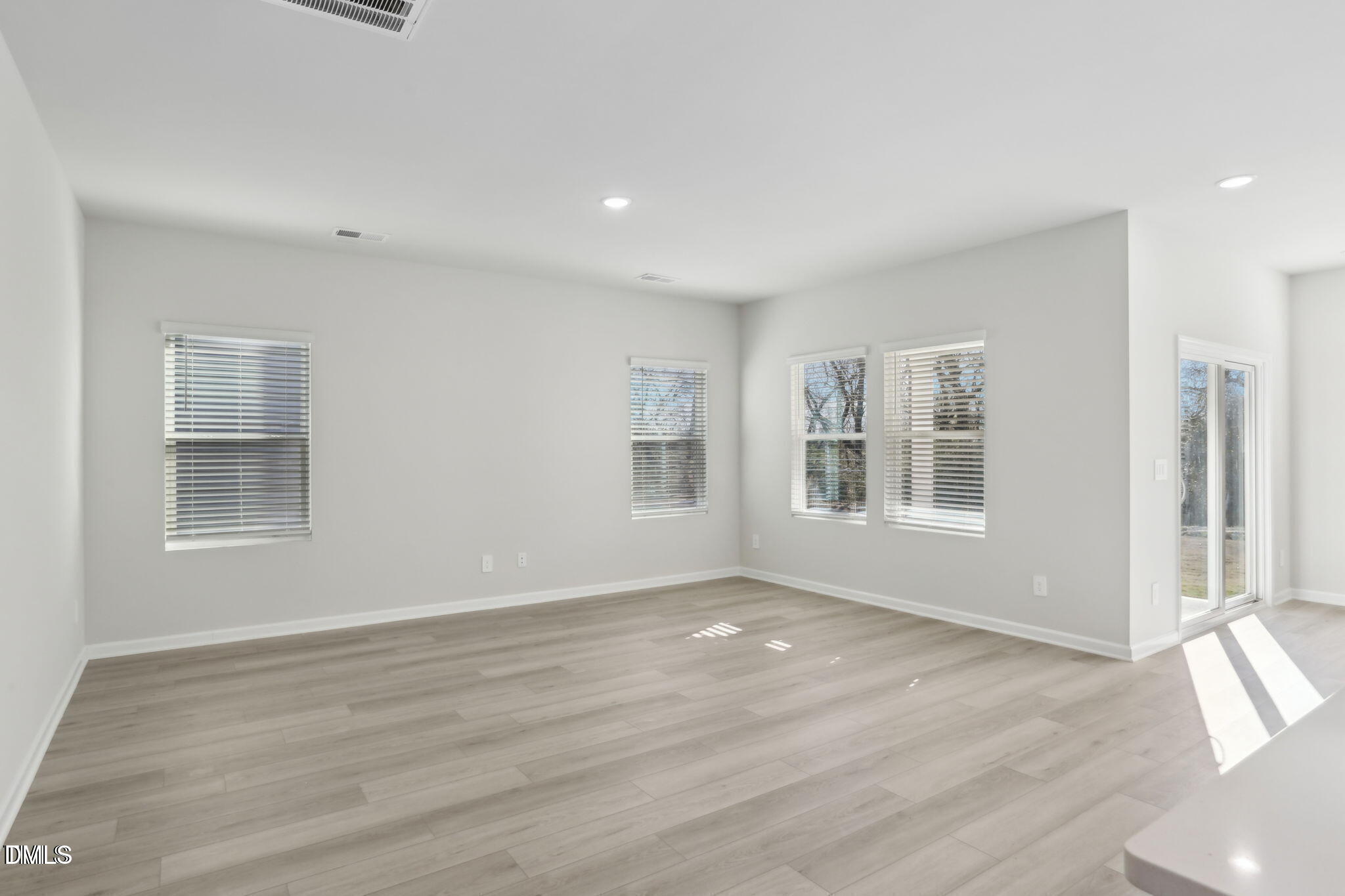 283 White Birch Lane Angier, NC 27501 - Photo 5 of 12 a view of an empty room with wooden floor and a window