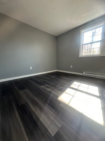 15-17 Otis Court, Unit 15 Springfield, MA 01119 - Photo 9 of 16 an empty room with wooden floor and windows