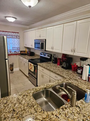 a kitchen with stainless steel appliances granite countertop a refrigerator stove and sink