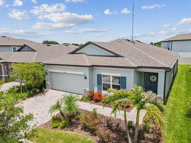 a front view of a house with a yard and potted plants