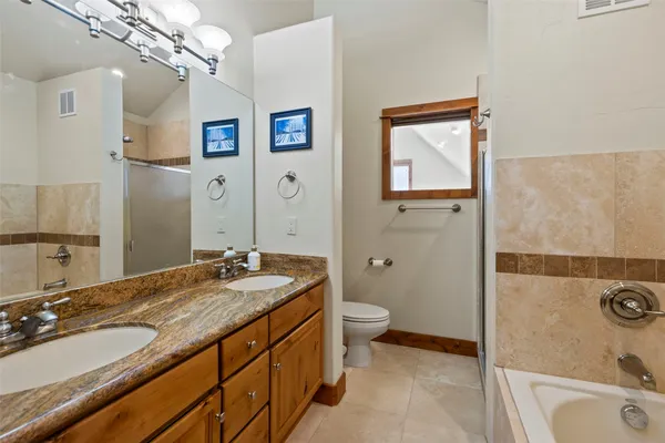 a bathroom with a granite countertop sink mirror vanity and toilet