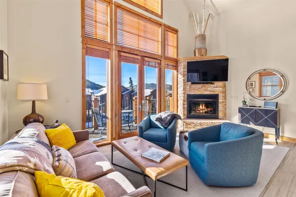 a living room with furniture a large window and a fireplace