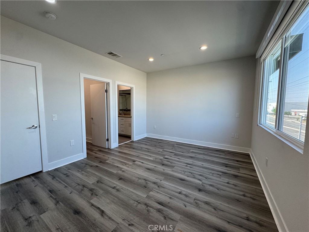 7958 Telegraph Road Downey, CA 90240 - Photo 11 of 38 a view of an empty room with wooden floor and a window