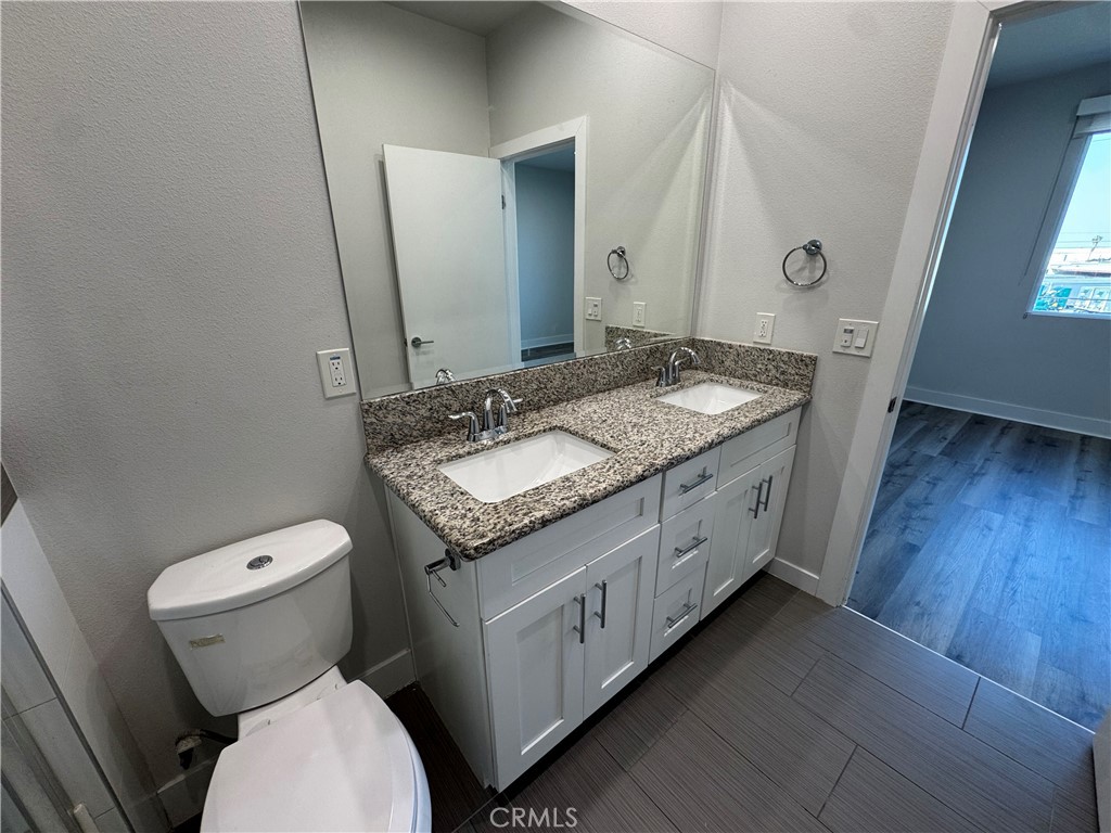 7958 Telegraph Road Downey, CA 90240 - Photo 14 of 38 a spacious bathroom with a granite countertop toilet a sink and a mirror