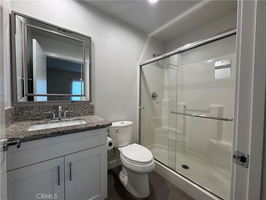 7958 Telegraph Road Downey, CA 90240 - Photo 24 of 38 a bathroom with a granite countertop sink toilet a mirror and shower