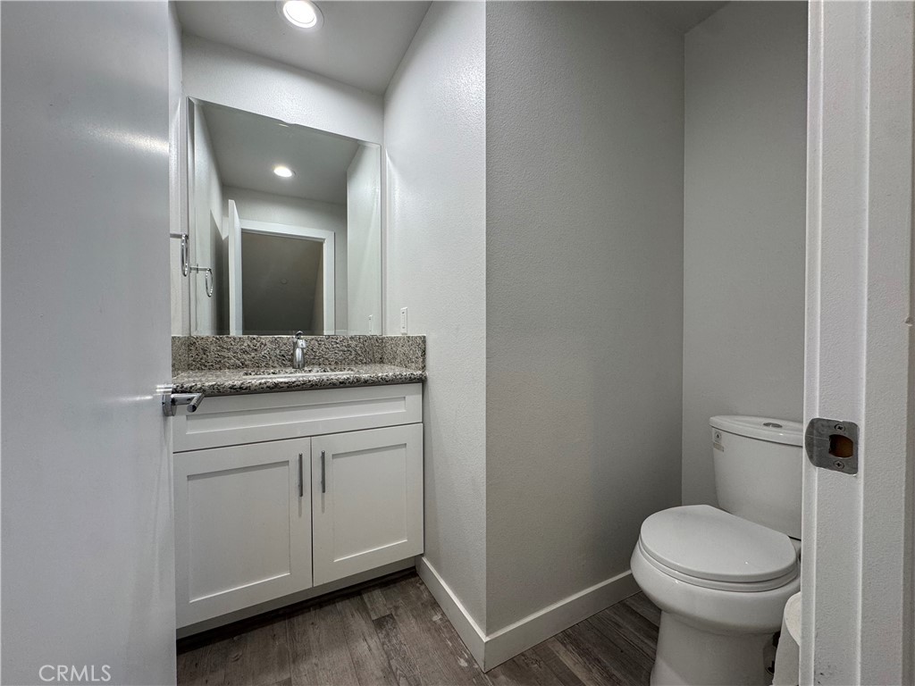 7958 Telegraph Road Downey, CA 90240 - Photo 8 of 38 a bathroom with a granite countertop toilet sink and mirror