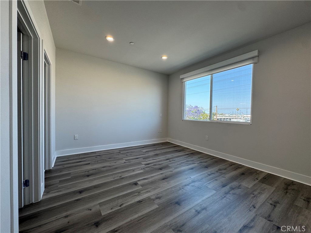 7958 Telegraph Road Downey, CA 90240 - Photo 10 of 38 a view of an empty room with wooden floor and a window