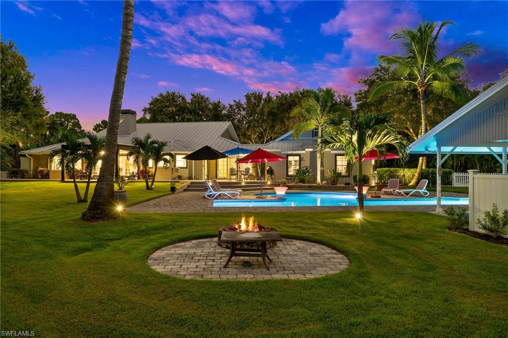 153 West Street Naples, FL 34108 - Photo 2 of 48 a swimming pool with outdoor seating and yard