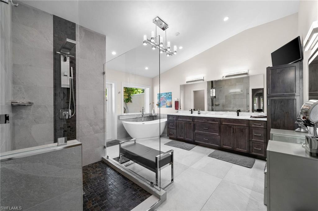 153 West Street Naples, FL 34108 - Photo 22 of 48 a large living room with stainless steel appliances kitchen island granite countertop a refrigerator a stove a sink dishwasher and a dining table with wooden floor