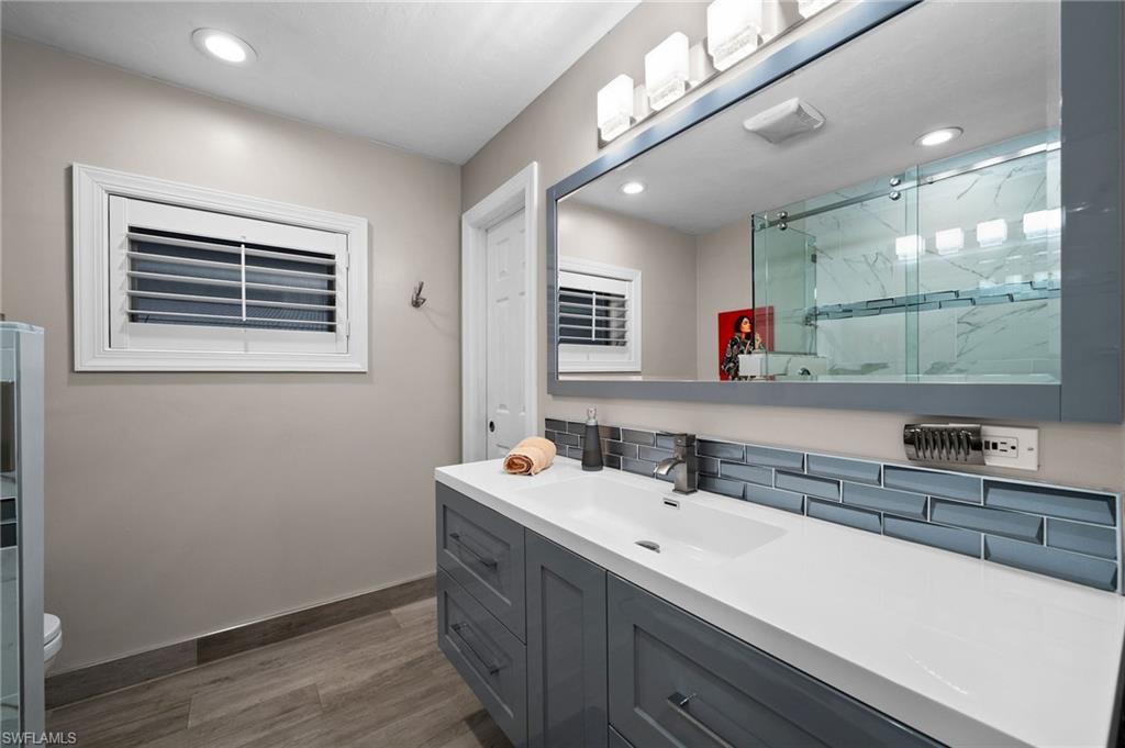 153 West Street Naples, FL 34108 - Photo 25 of 48 a bathroom with a sink a large mirror and a window