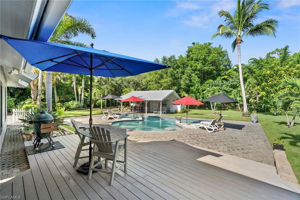 153 West Street Naples, FL 34108 - Photo 32 of 48 a view of a table and chairs under an umbrella in patio