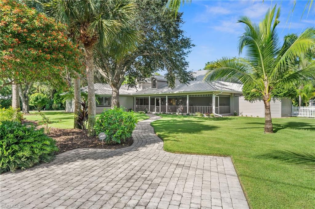 153 West Street Naples, FL 34108 - Photo 6 of 48 a front view of a house with a garden