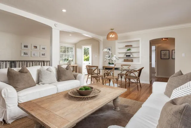 a living room with furniture kitchen view and a table