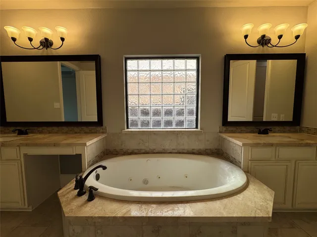 a bathroom with a tub sink and mirror