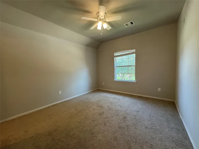an empty room with windows and ceiling fan