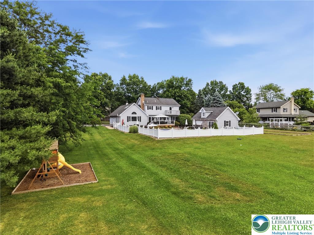 890 Lahr Road Nazareth, PA 18064 - Photo 70 of 71 A spacious, verdant yard with a white picket fence bordering neighboring homes, perfect for outdoor activities.