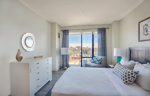 a bedroom with a bed and a large window