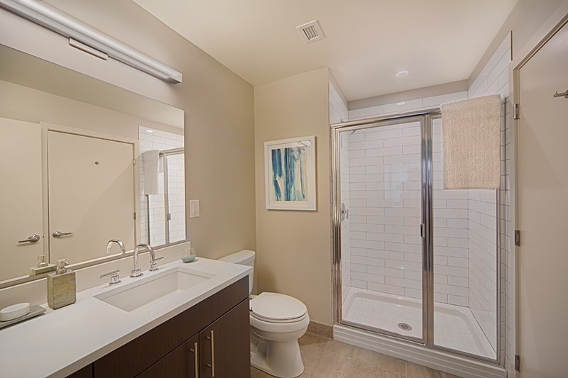 1 Canal Street, Unit 1012 Boston, MA 02114 - Photo 5 of 12 a bathroom with a double vanity sink toilet mirror and shower