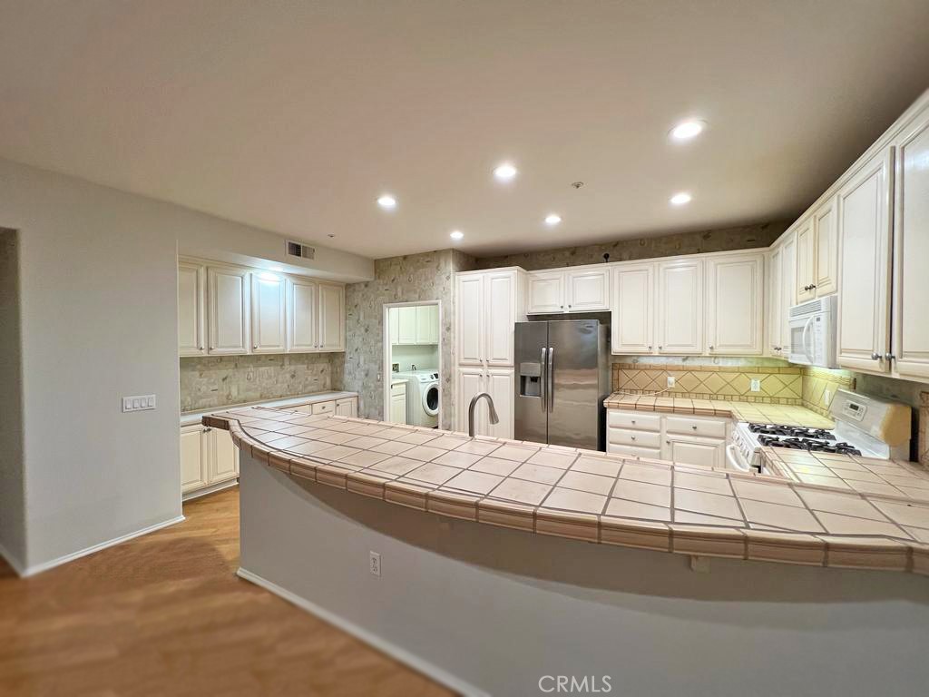 3 Leucadia Irvine, CA 92602 - Photo 4 of 30 a large kitchen with kitchen island a sink stainless steel appliances and cabinets