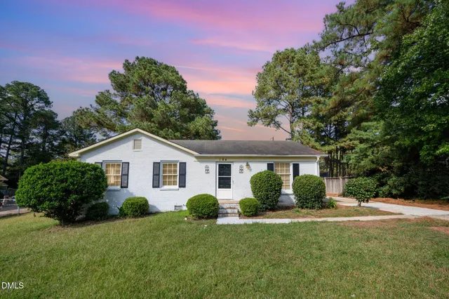 a view of a house with a yard and potted plants