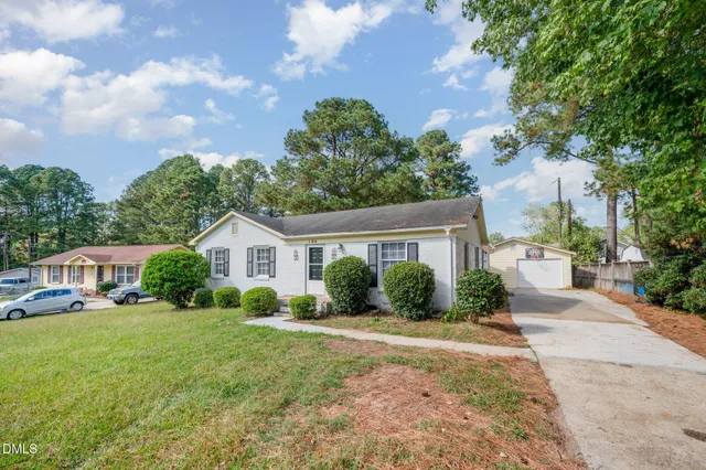 a view of a house with a yard and potted plants
